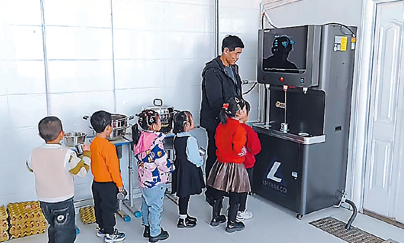 图为孩子们在新安装的饮水机前排队接水。郭杰 摄